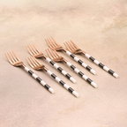 Rose gold dinner forks with black and white striped handles