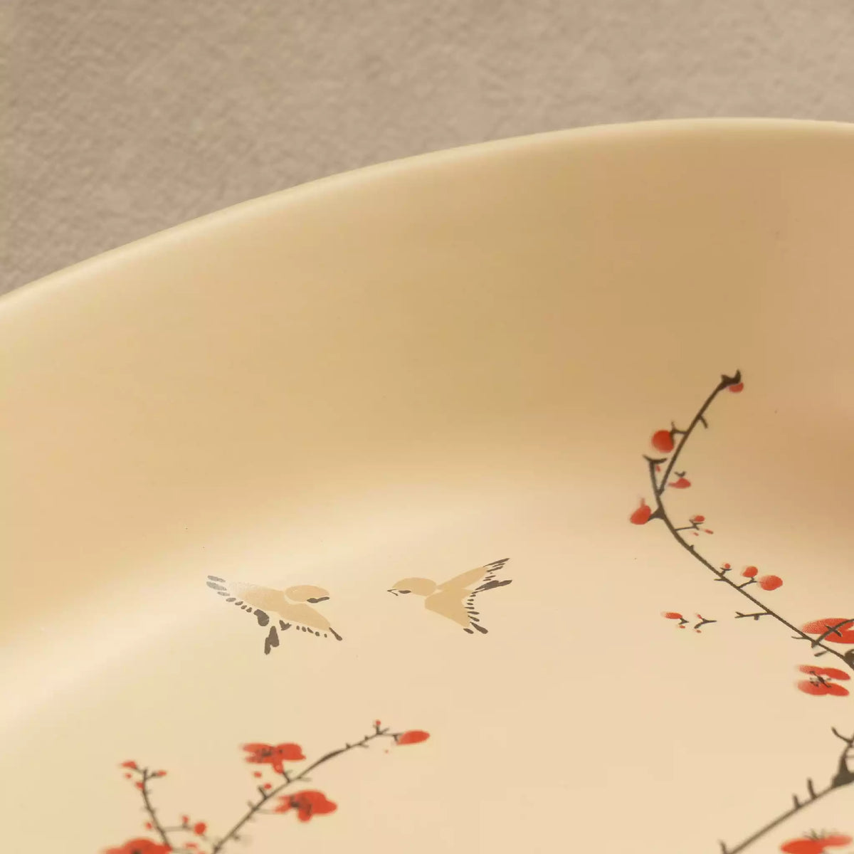 Close-up of Sakura baking dish rim with blossom and bird motif