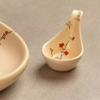 Sakura ceramic ladle spoon upright beside oval platter