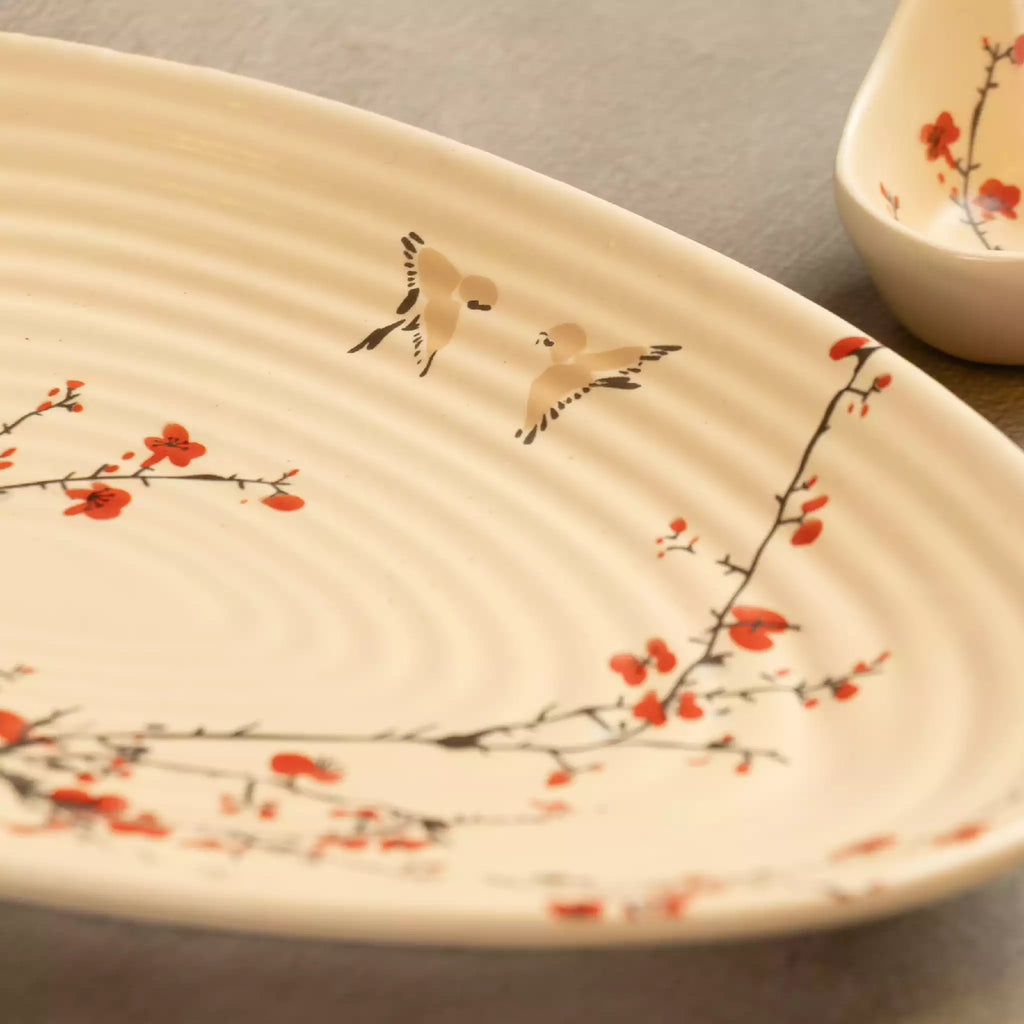 Close-up of Sakura leaf platter with red blossom and bird painting