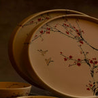 Sakura dinner plates stacked with bowl, warm-lit blossom ceramic