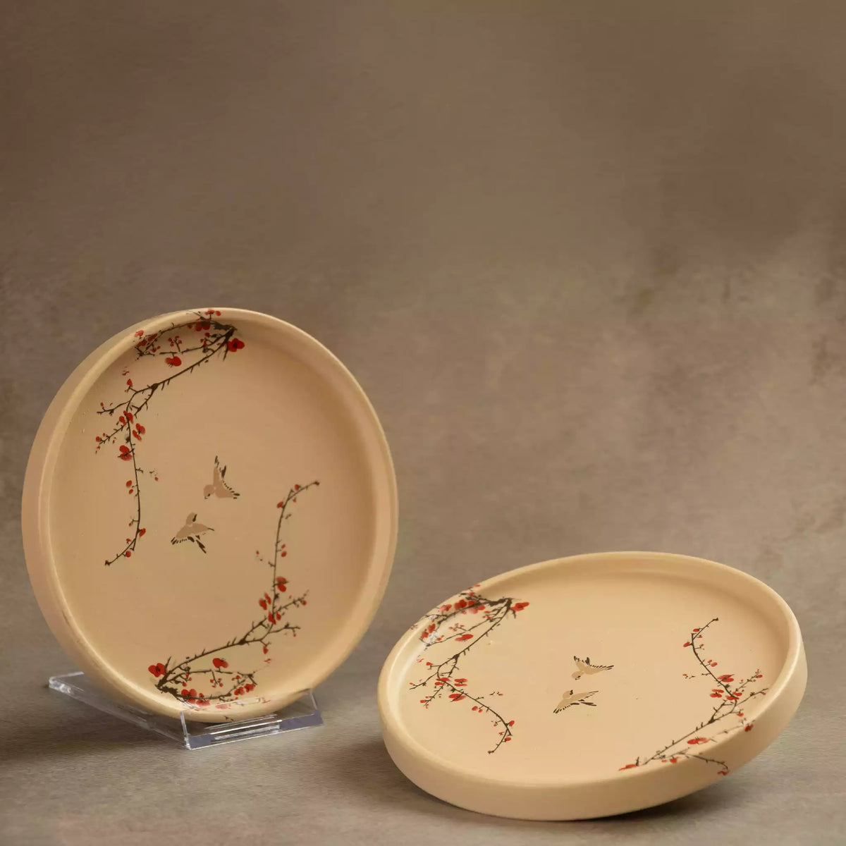 Sakura side plate upright beside flat plate on grey backdrop