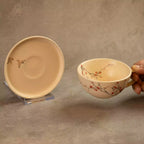 Sakura tea cup held beside matching saucer with blossom detail