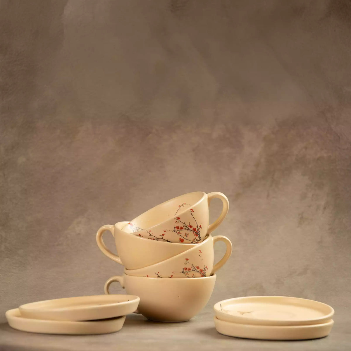 Stacked Sakura tea cups and saucers in beige cherry blossom ceramic