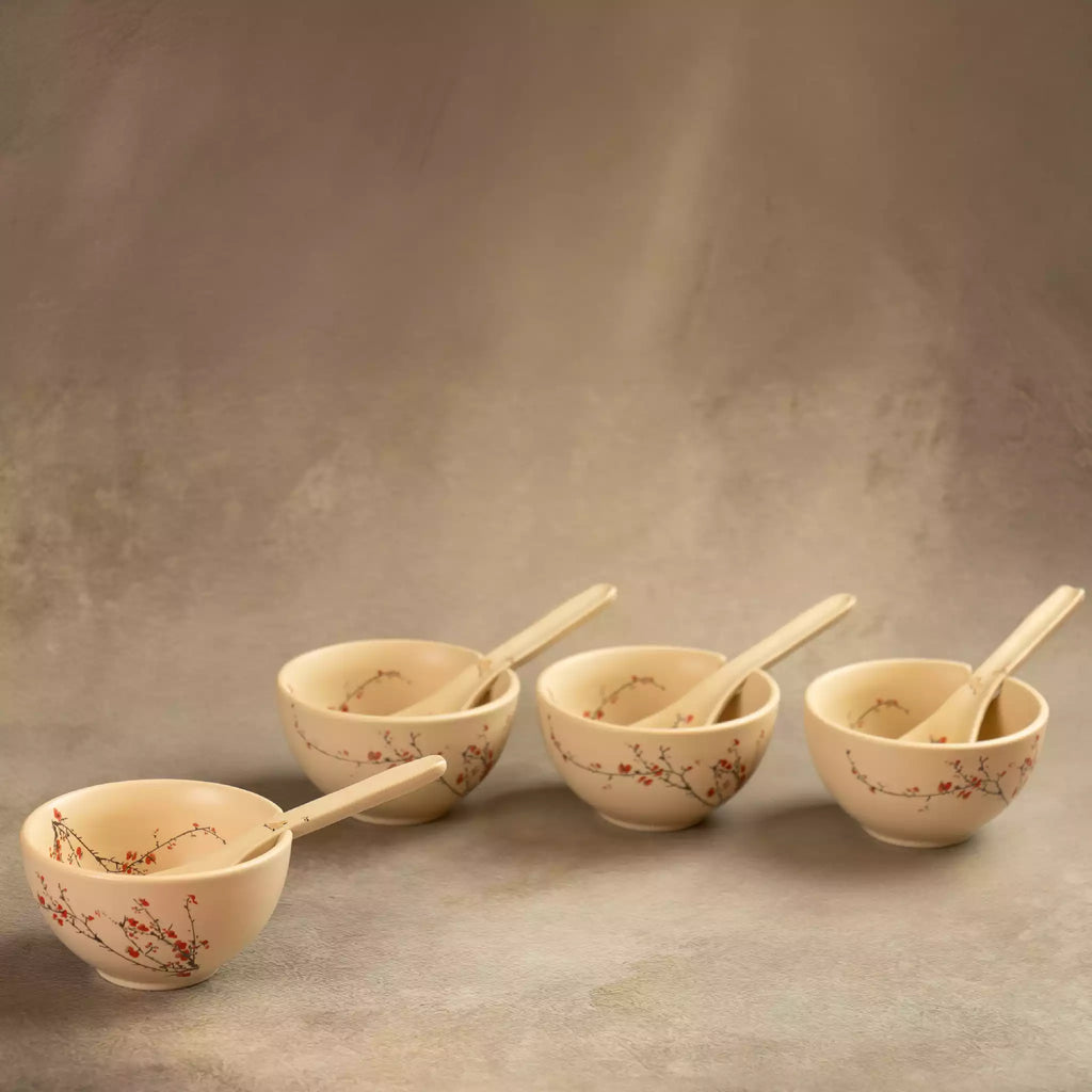 Three Sakura soup bowls with spoons lined up on grey backdrop