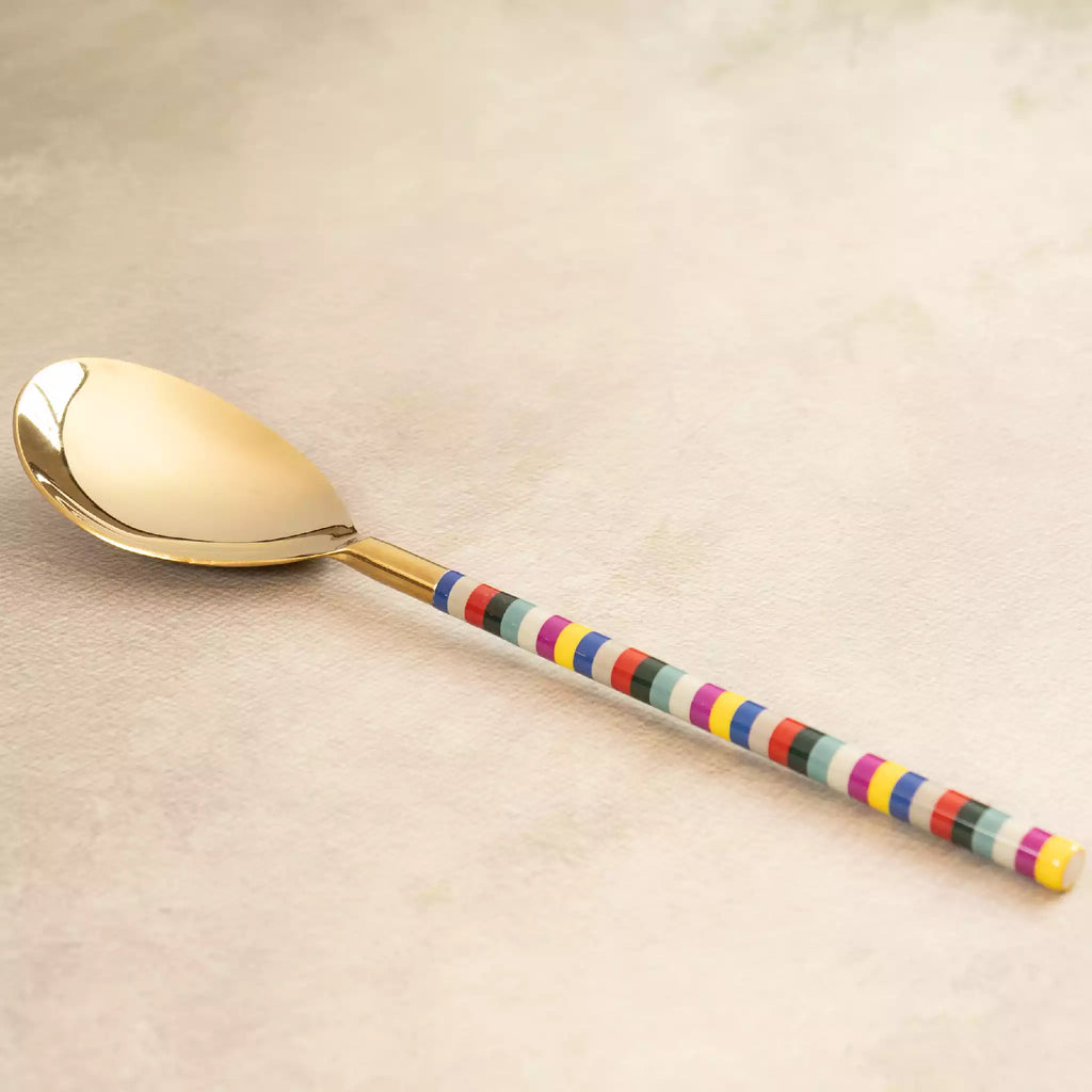 Rainbow gold serving spoon angled view with striped handle