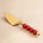 Bubbles brass cake server with red beaded handle