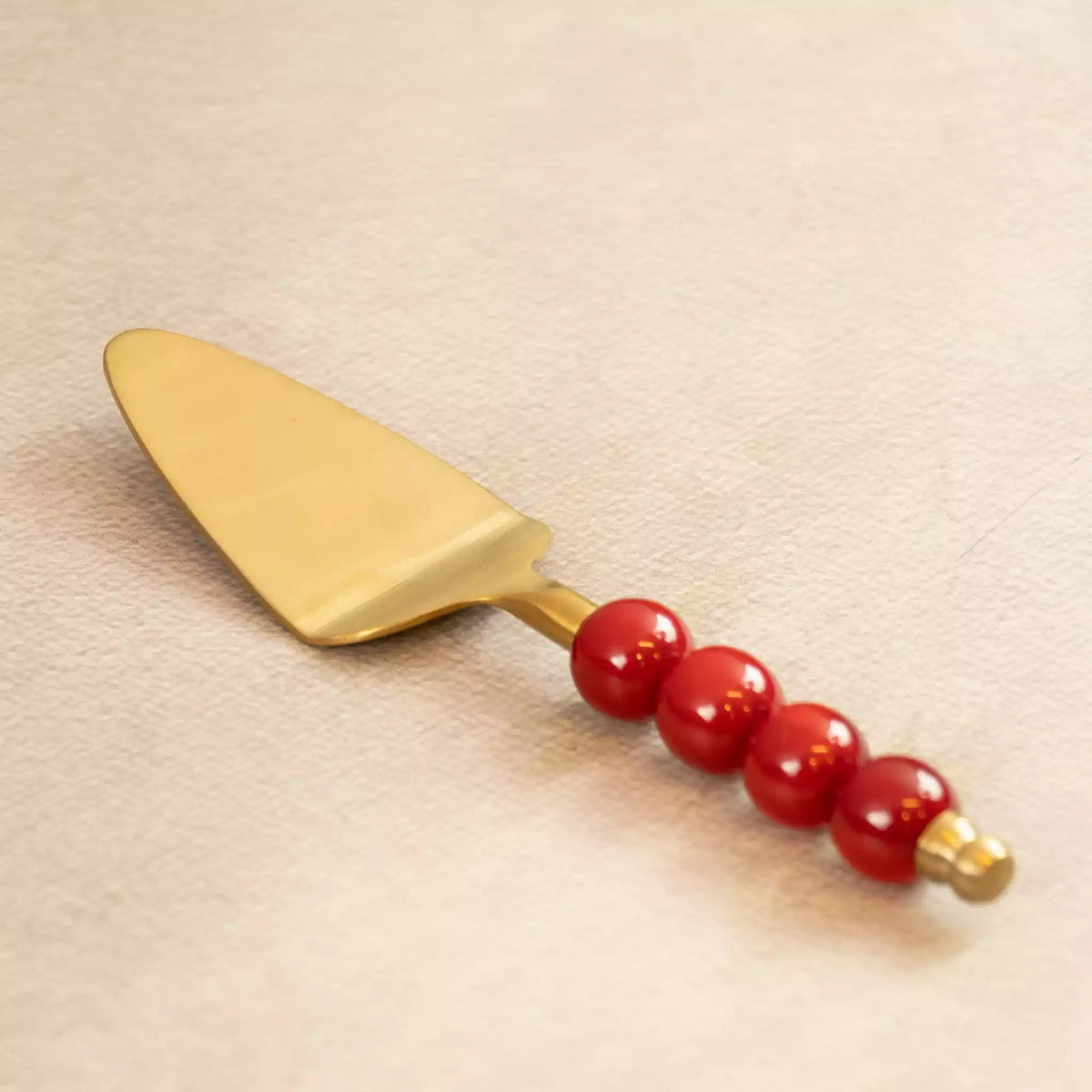 Bubbles brass cake server with red beaded handle