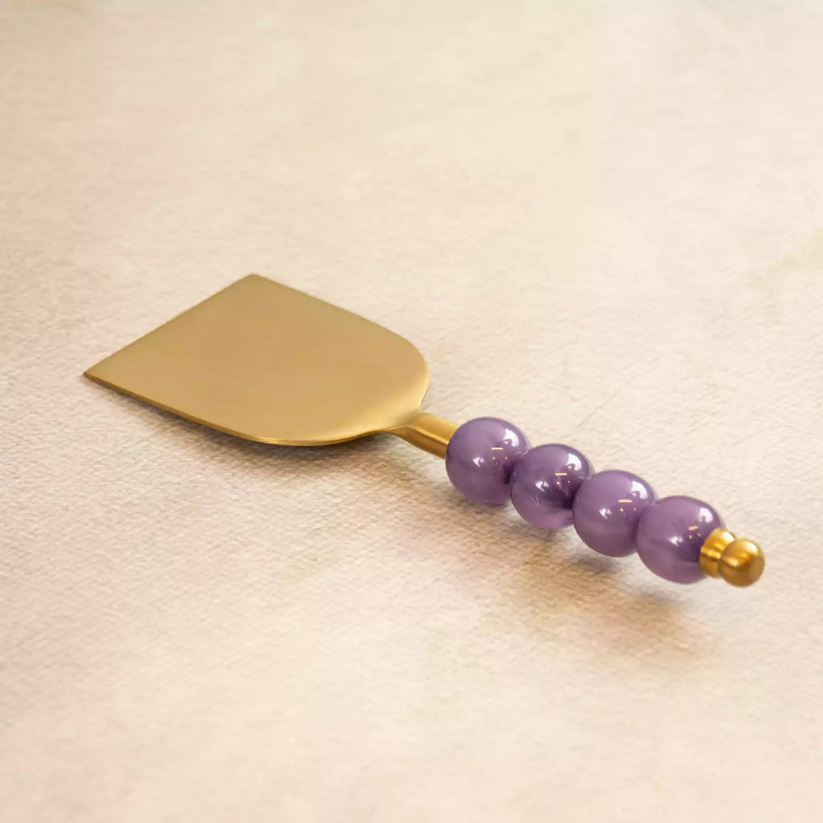Bubbles brass spatula with purple beaded handle