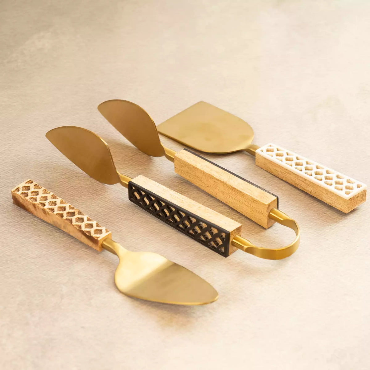 Carved brass tongs and spatulas trio with textured handles
