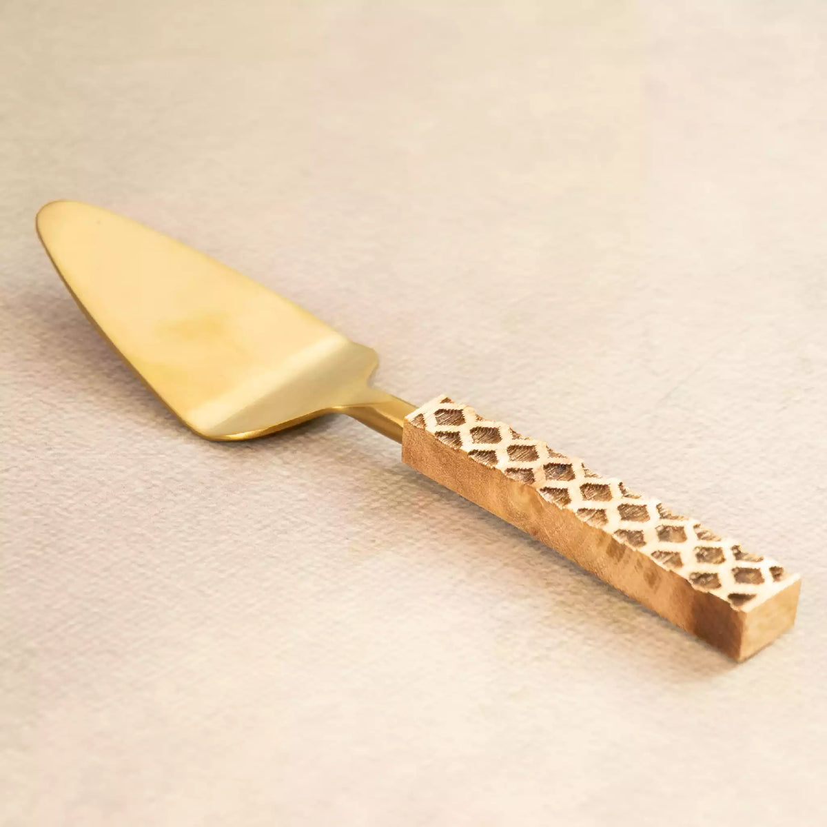 Brass cake server with perforated carved handle