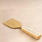 Carved brass cheese spatula with cut-work handle from serving trio