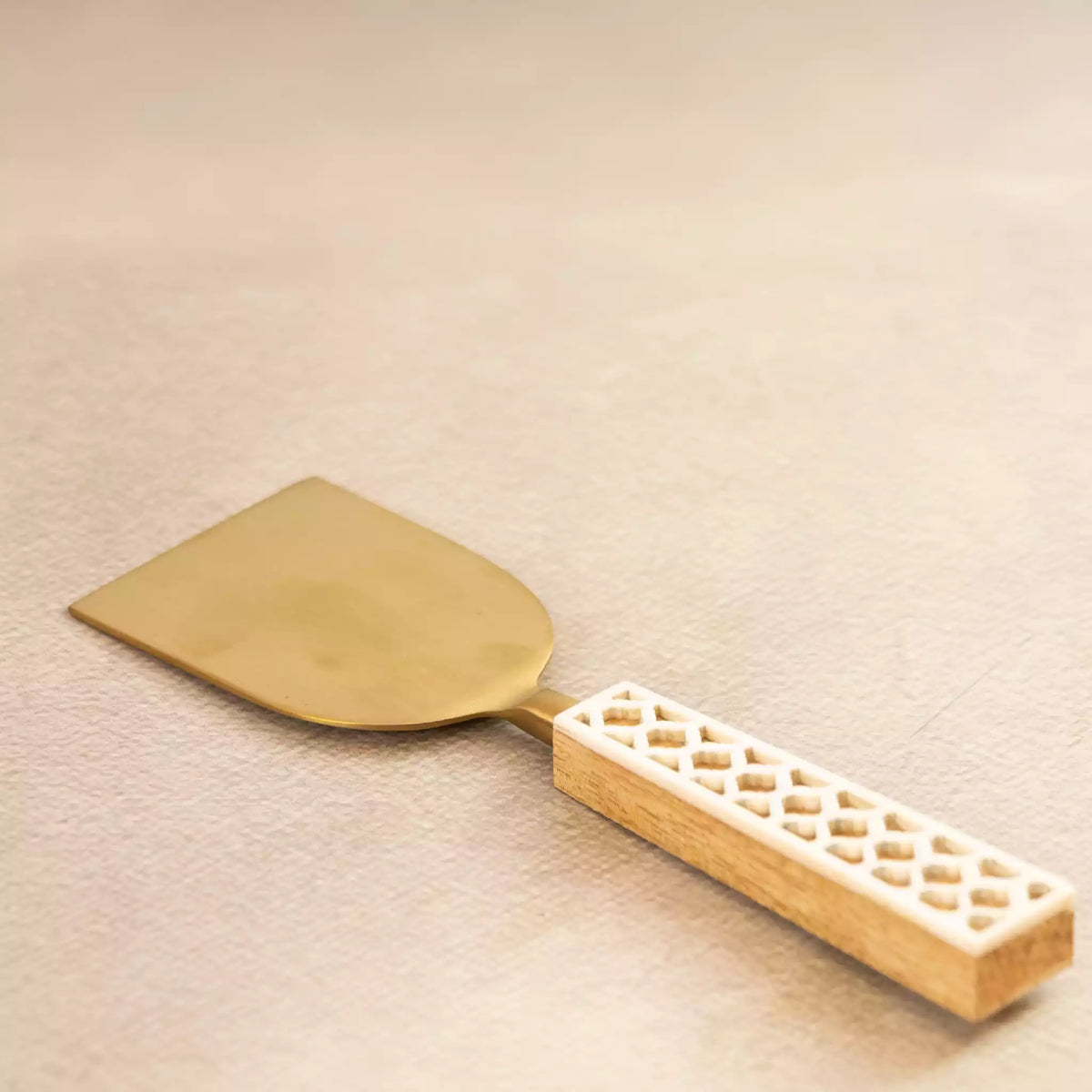 Carved brass cheese spatula with cut-work handle from serving trio
