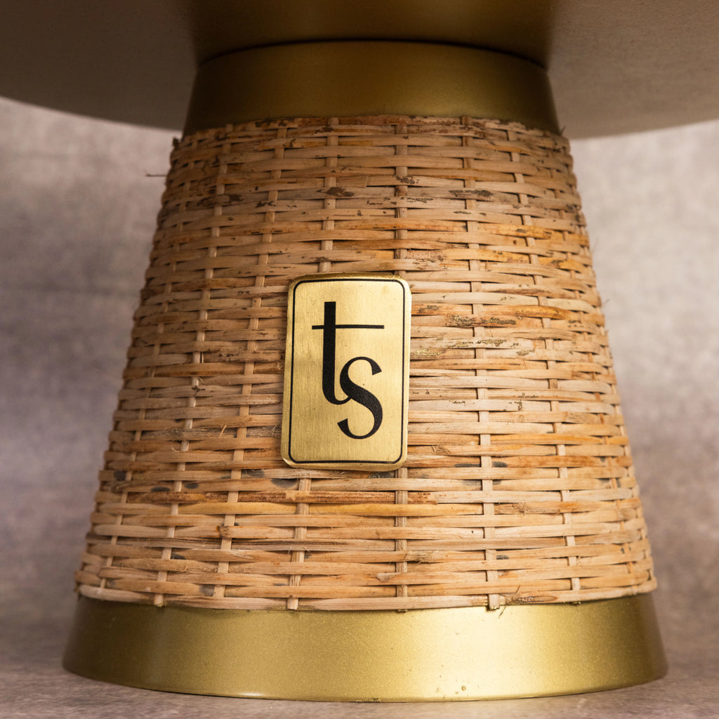 Wicker cake stand base close-up with brand medallion