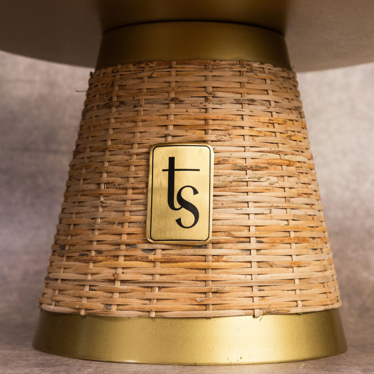 Wicker cake stand base close-up with brand medallion